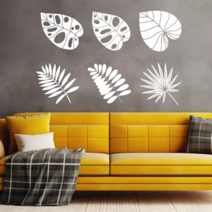 Silhouette Leaf Wall Sticker Set with Six Tropical Leaf Shapes on a Grey Wall Above a Yellow Sofa